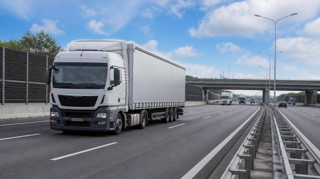 Autocarri per il trasporto merci attraversano una piattaforma logistica europea.
